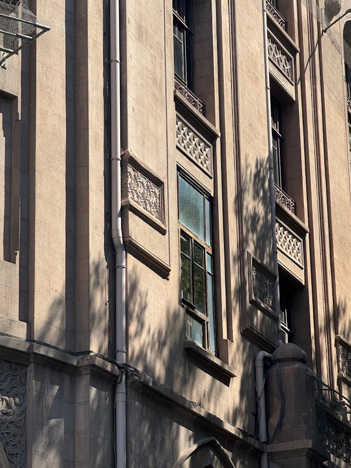 Close-up view of a historic building facade with shadows, highlighting intricate details.