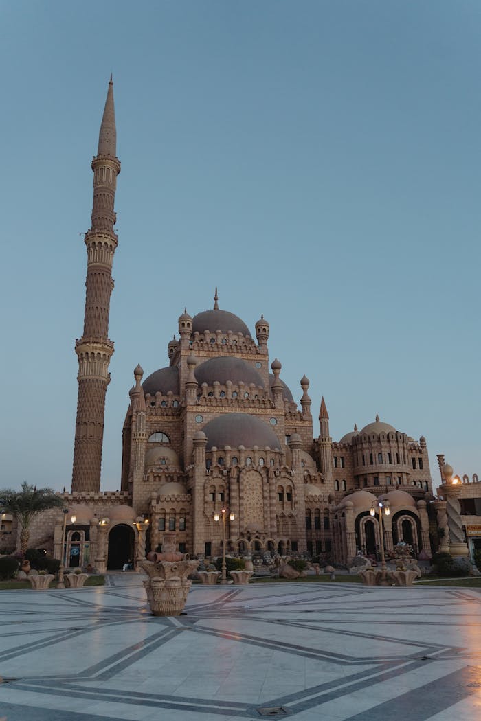 Beautiful view of Al Sahaba Mosque's intricate facade and towering minaret against a clear dusk sky in Sharm el-Sheikh, Egypt.